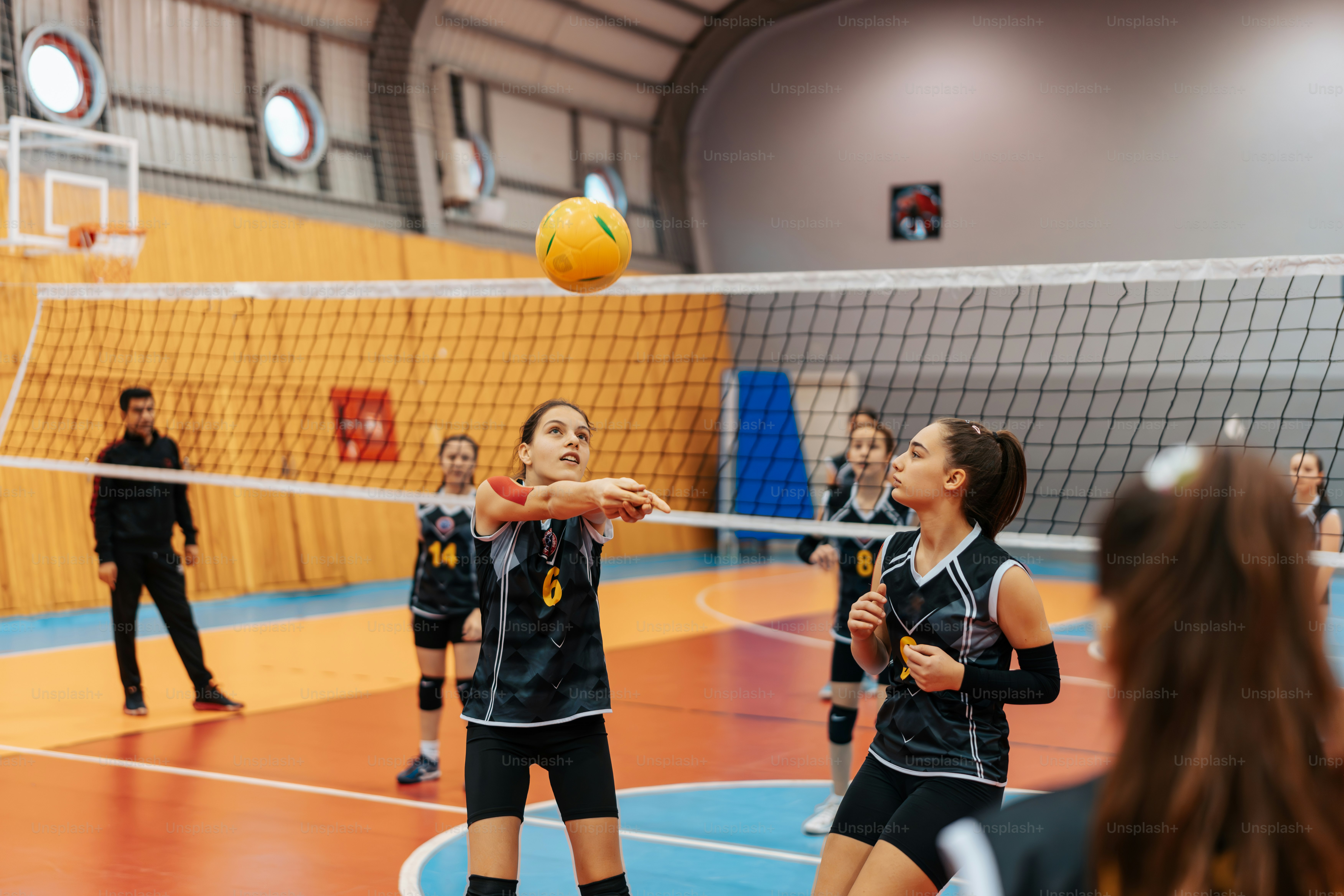a group of young women playing a game of volleyball