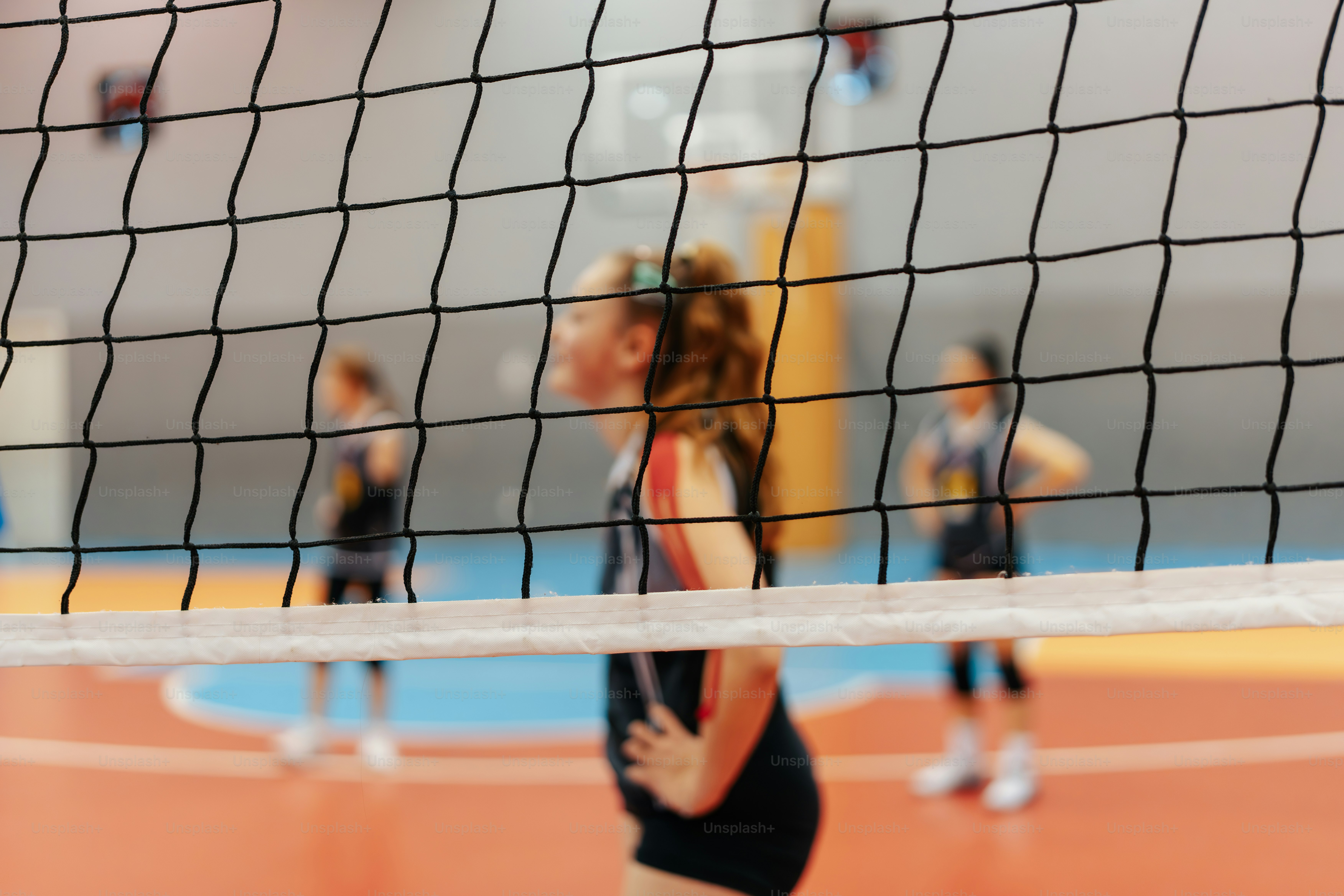 Volleyball players behind a net