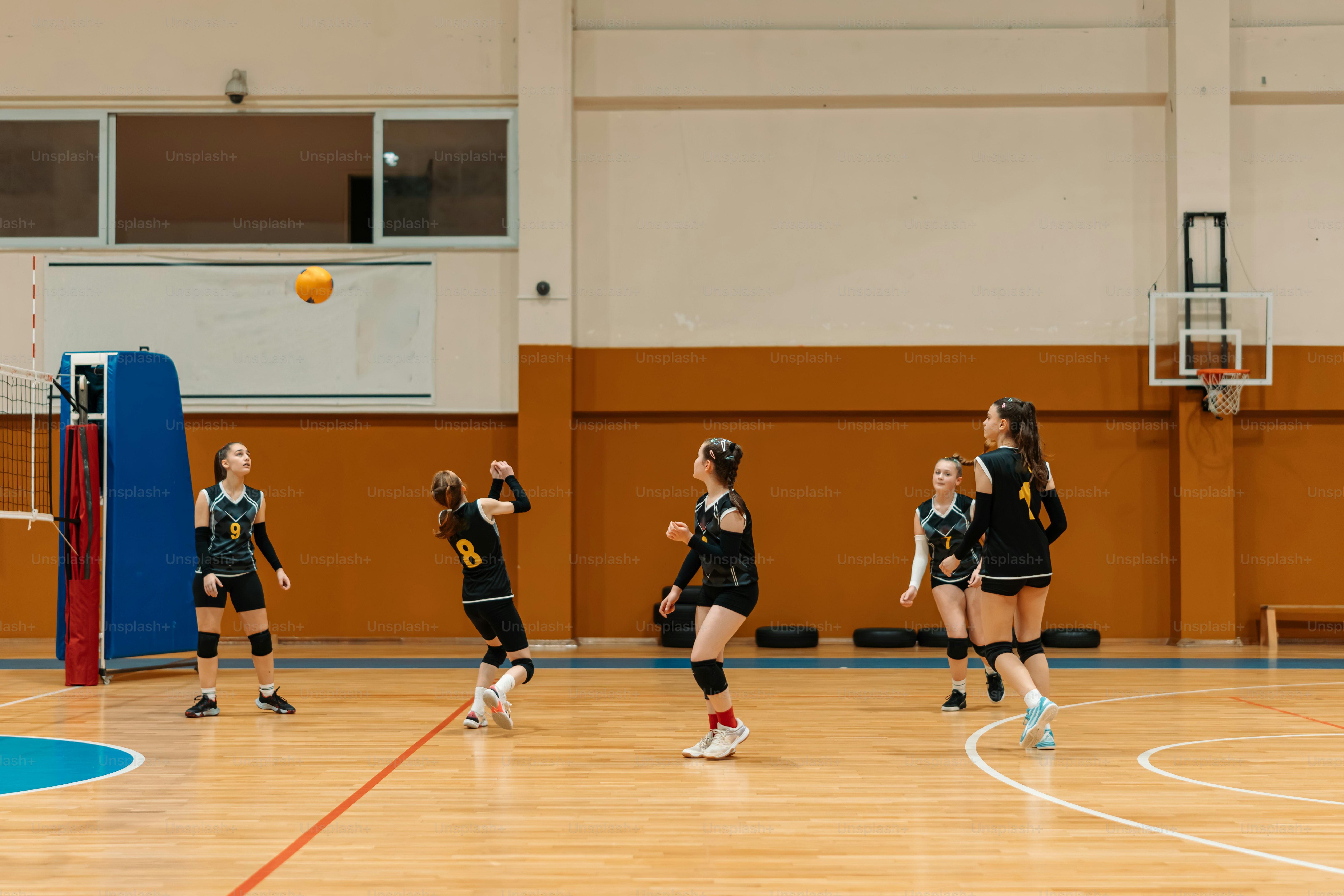 a group of girls playing a game of volleyball