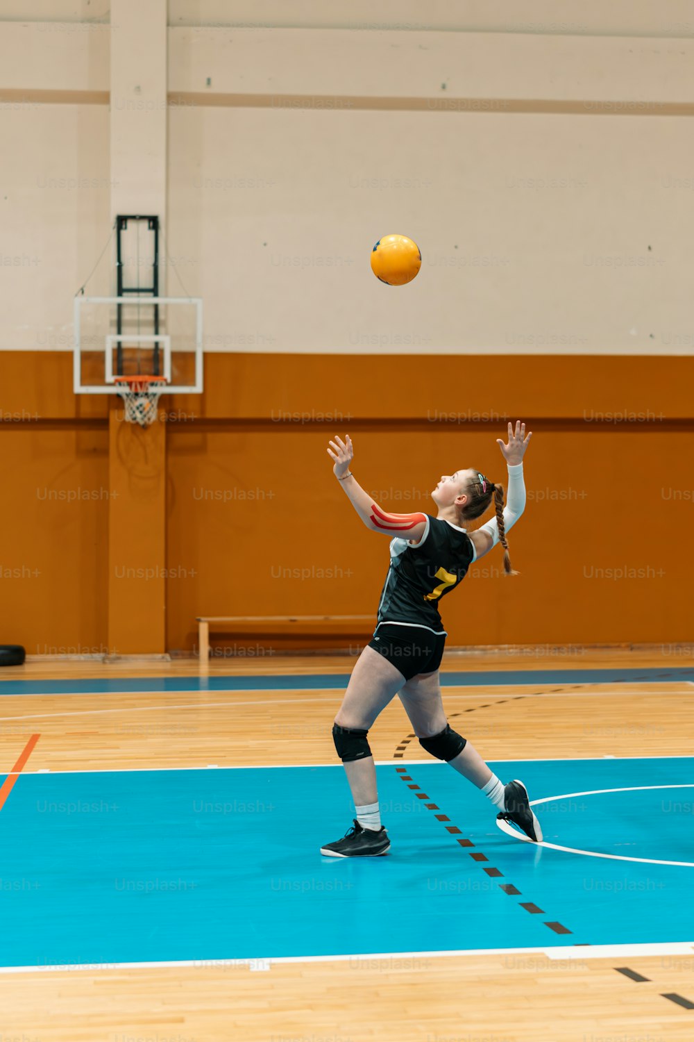 eine Frau, die nach oben greift, um einen Ball mit einem Schläger zu schlagen