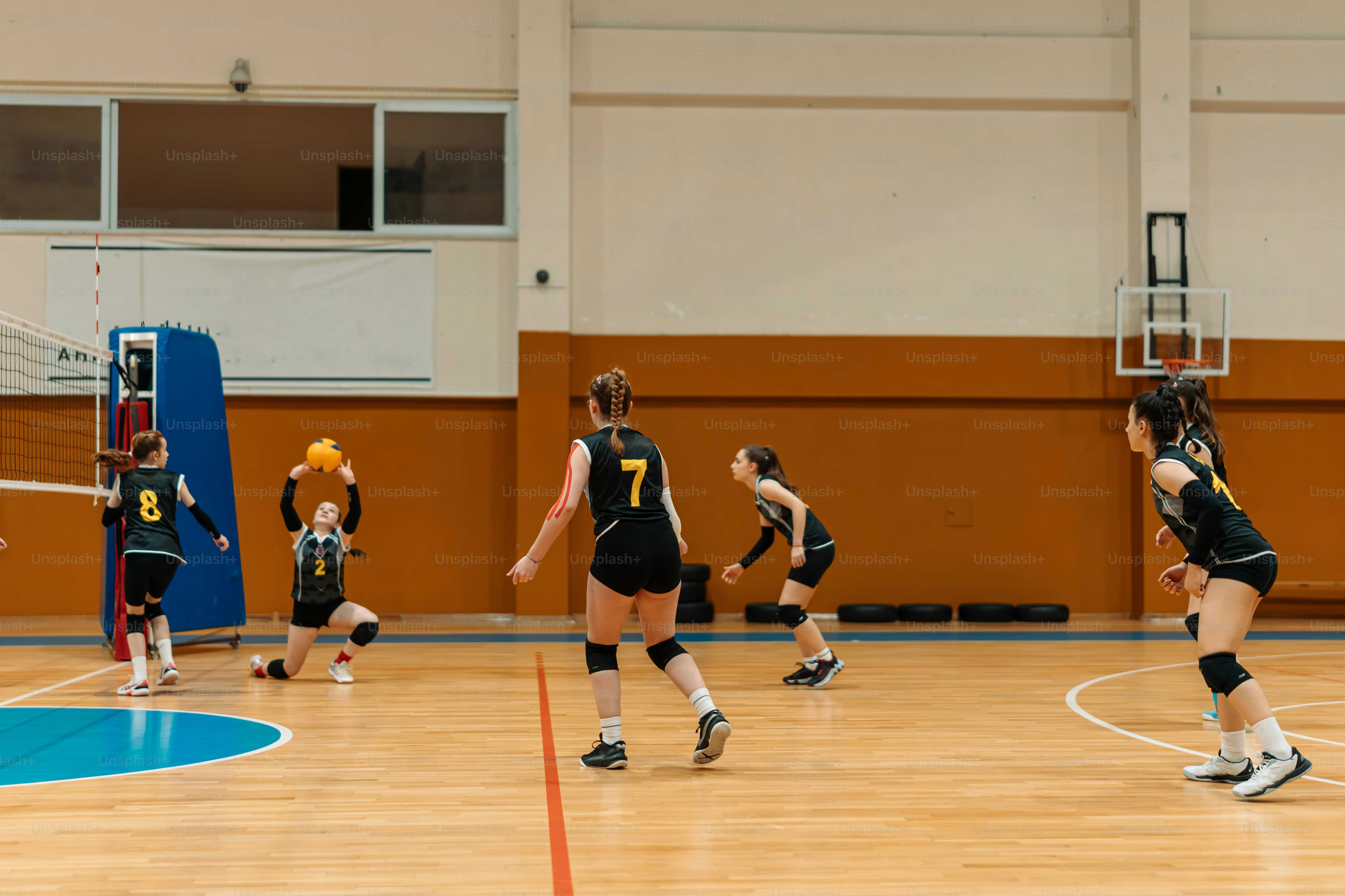 a group of young women playing a game of volleyball