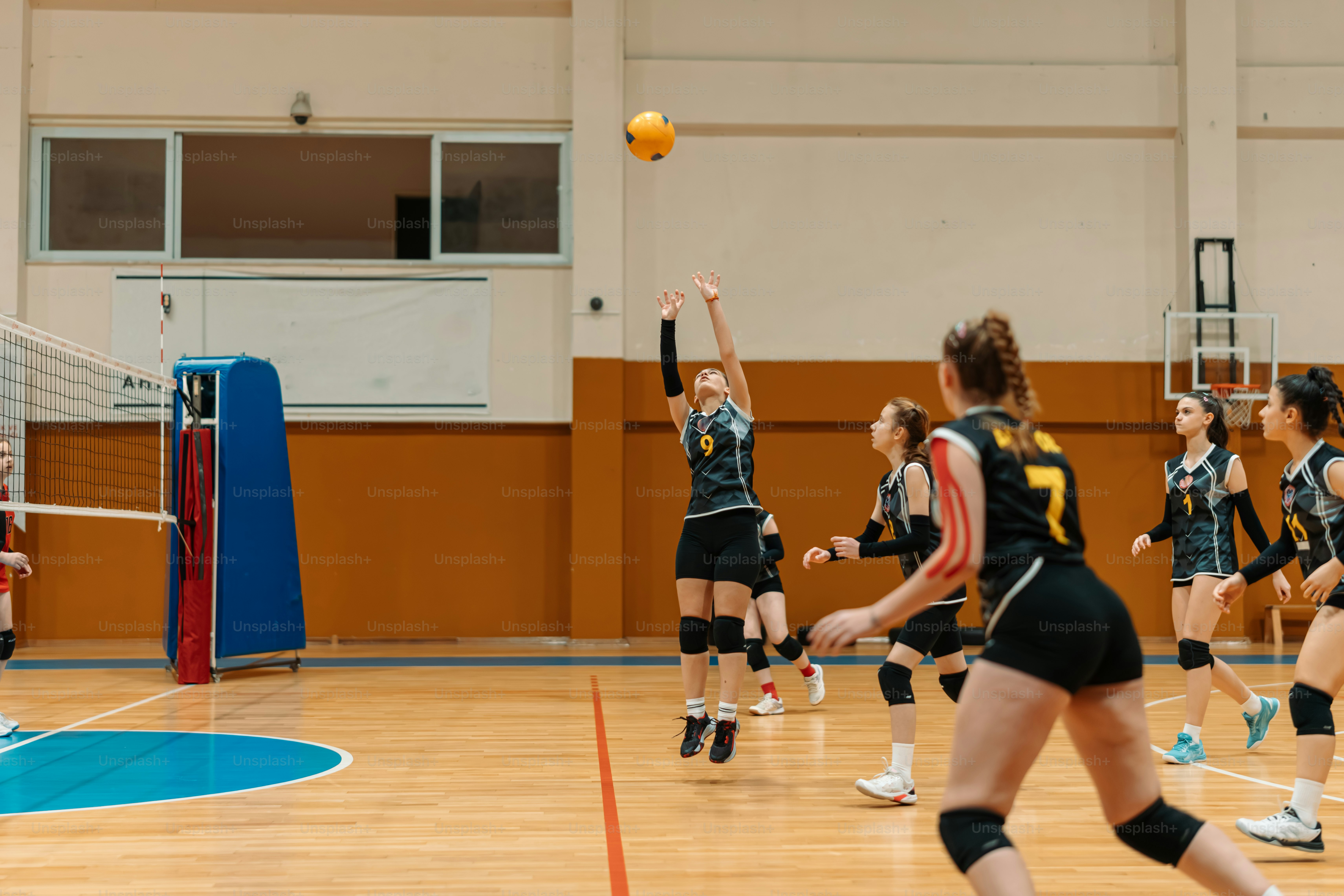 a group of young women playing a game of volleyball