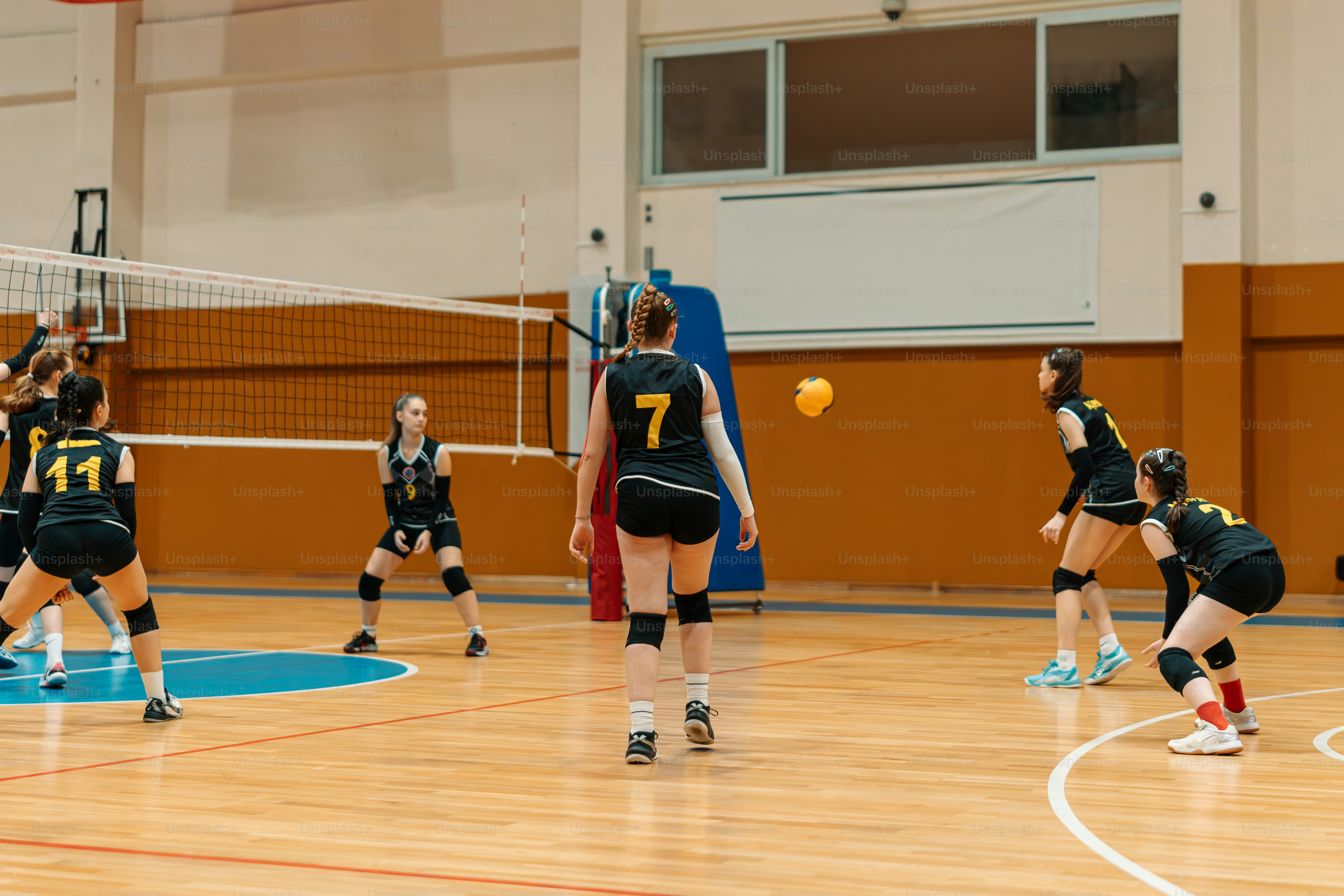 a group of young women playing a game of volleyball