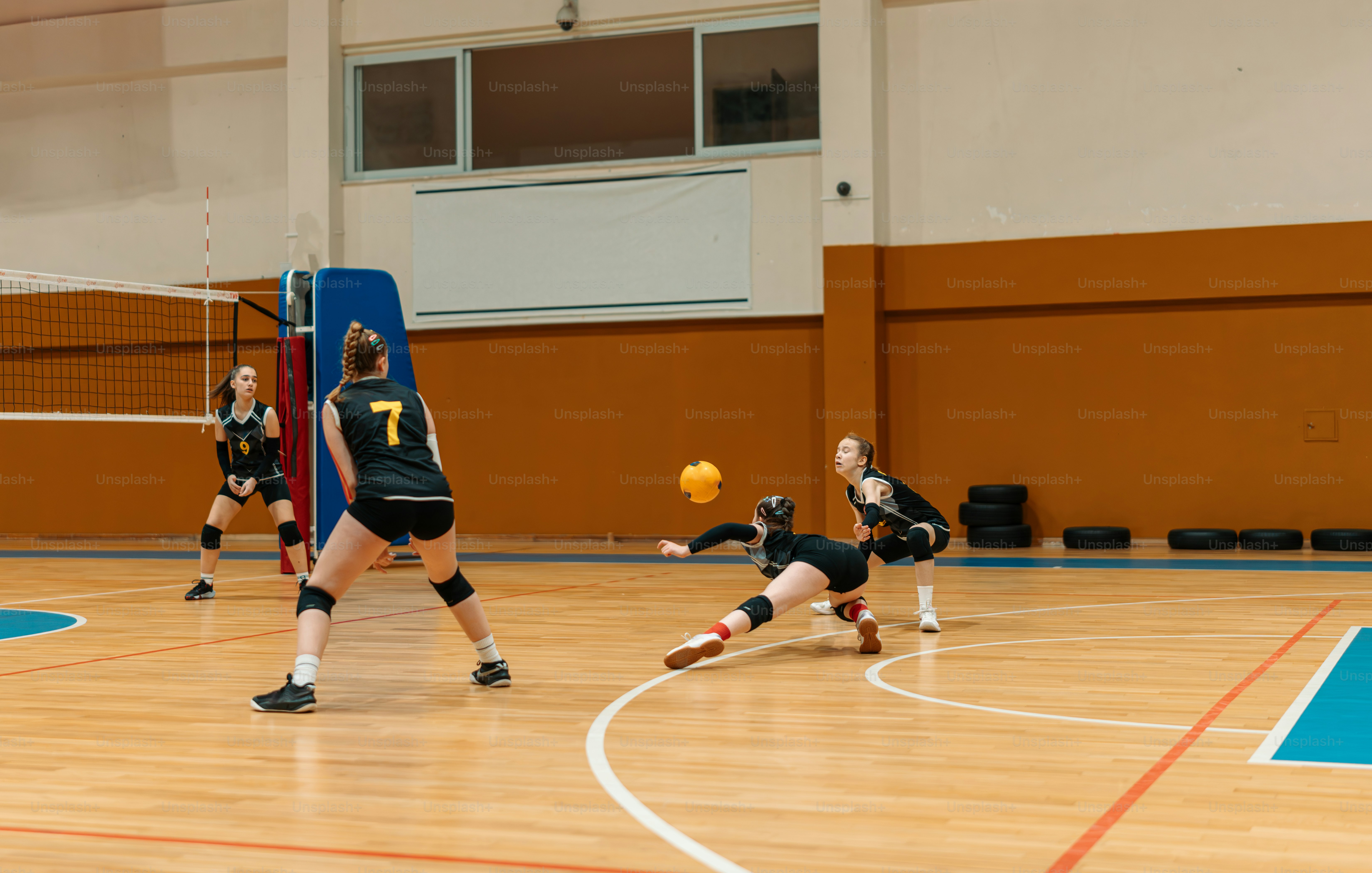 a group of young women playing a game of volleyball