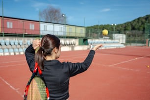 テニスコートの上でテニスラケットを持つ女性