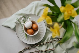 a white plate topped with eggs next to a vase of flowers