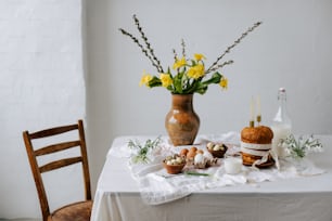 a table topped with a vase filled with yellow flowers
