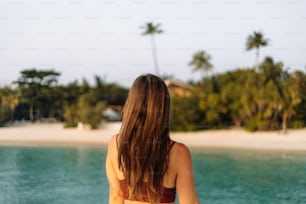 una donna in bikini in piedi su una spiaggia