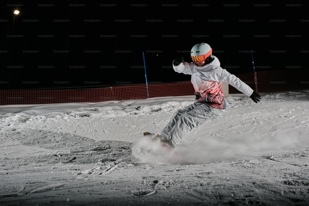 um homem montando um snowboard por uma encosta coberta de neve