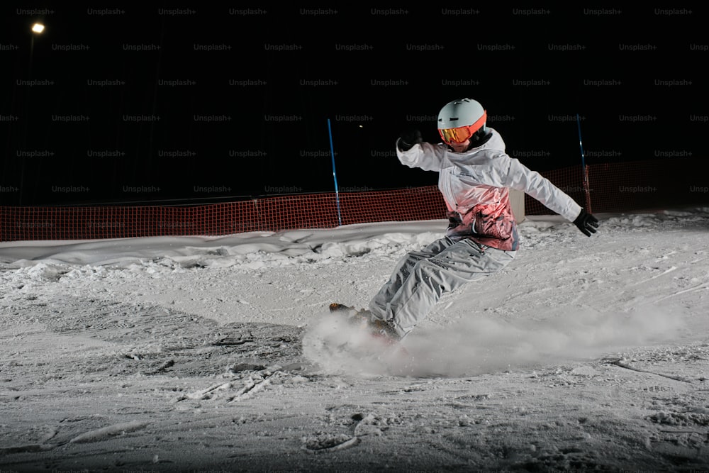 a man riding a snowboard down a snow covered slope