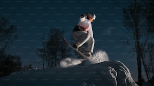 a man riding a snowboard down the side of a snow covered slope