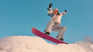 une personne qui fait de la planche à neige sur une surface enneigée