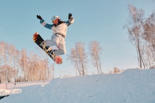 a man flying through the air while riding a snowboard