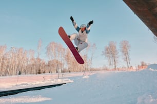 un uomo che vola nell'aria mentre cavalca uno snowboard