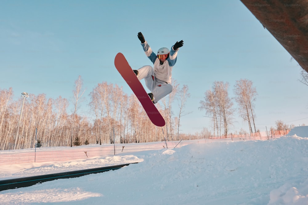 a man flying through the air while riding a snowboard