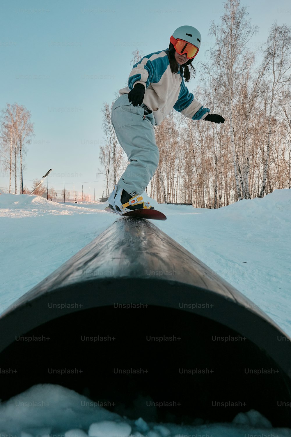 um homem montando um snowboard ao lado de um cano