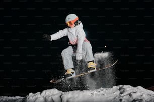 una persona su uno snowboard che salta in aria