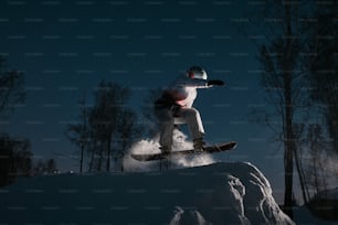 a man riding a snowboard down the side of a snow covered slope