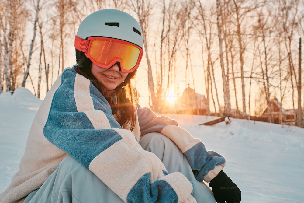 스키를 신고 눈밭에 앉아 있는 여성