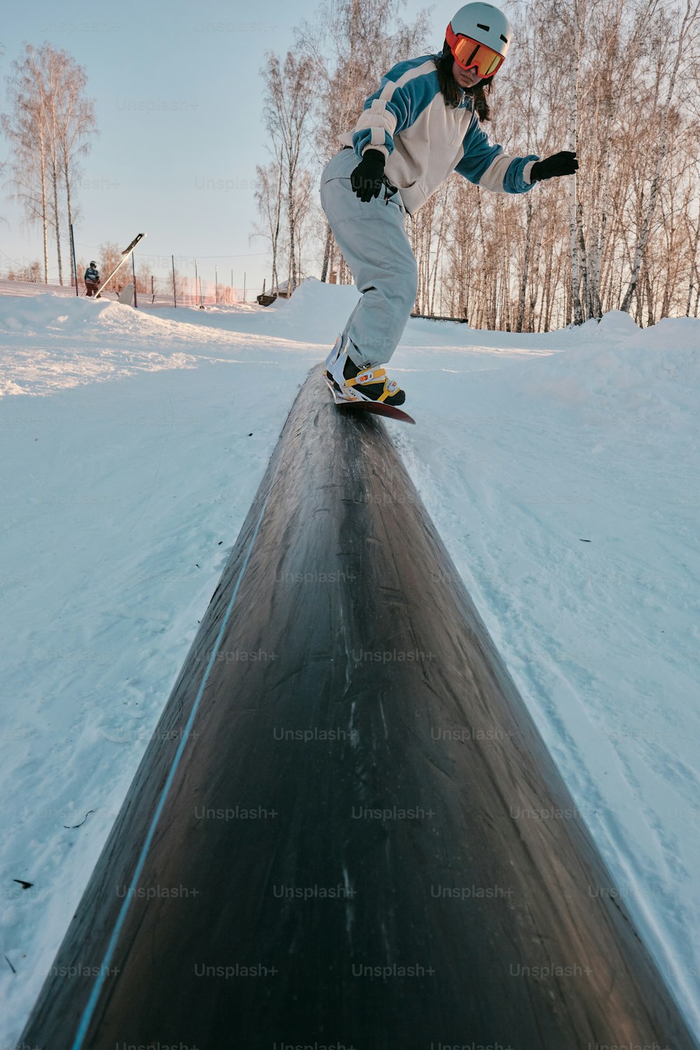 a man riding a snowboard down the side of a snow covered slope