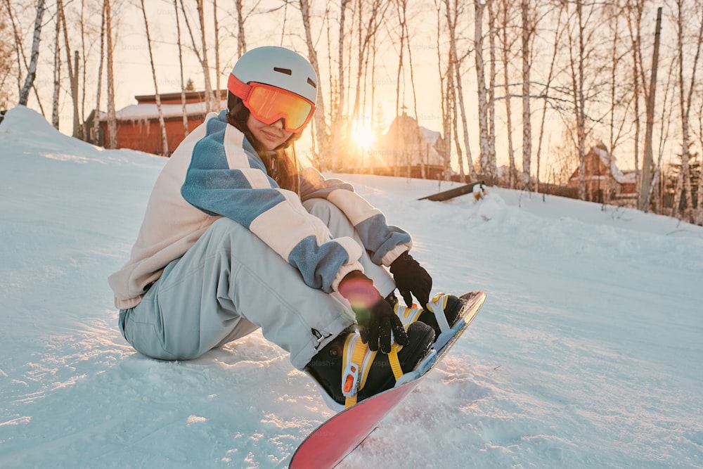 a person sitting in the snow with a snowboard