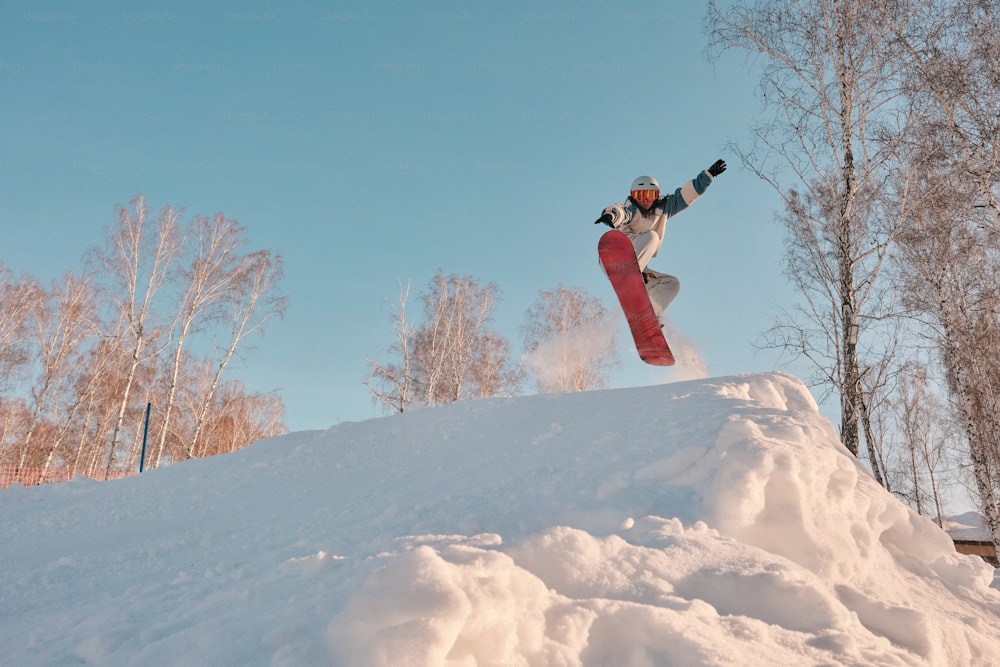 uma pessoa pulando uma prancha de neve no ar