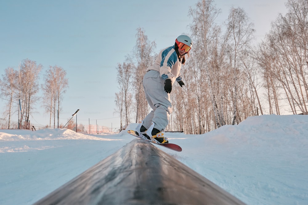 Ein Mann, der mit einem Snowboard die Seite eines schneebedeckten Hangs hinunterfährt