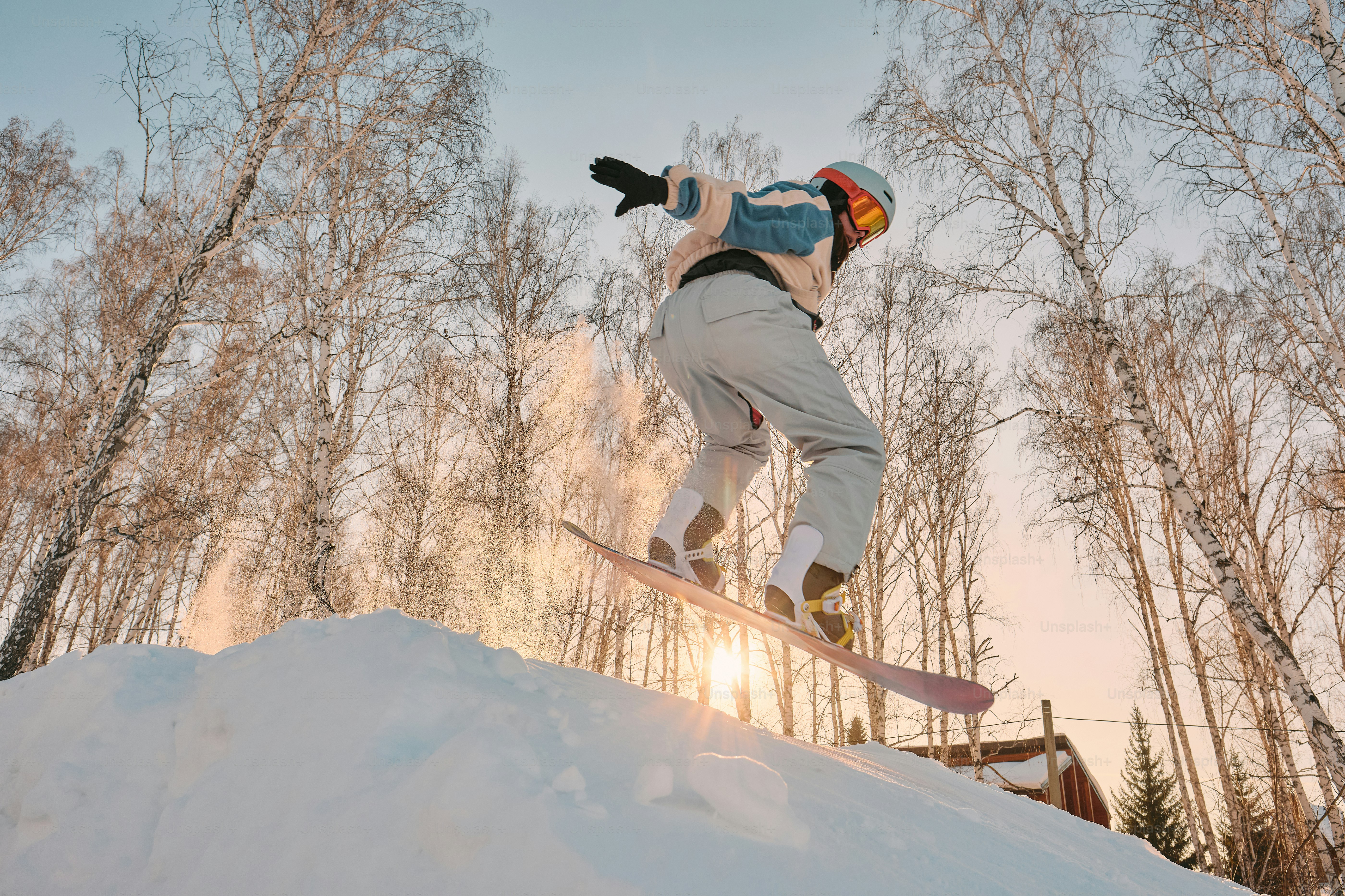Ein Mann, der mit einem Snowboard die Seite eines schneebedeckten Hangs hinunterfährt