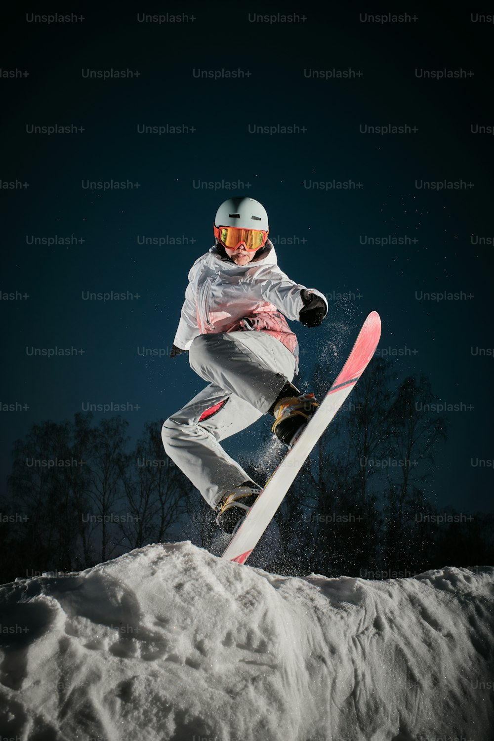 uma pessoa em um snowboard pulando no ar
