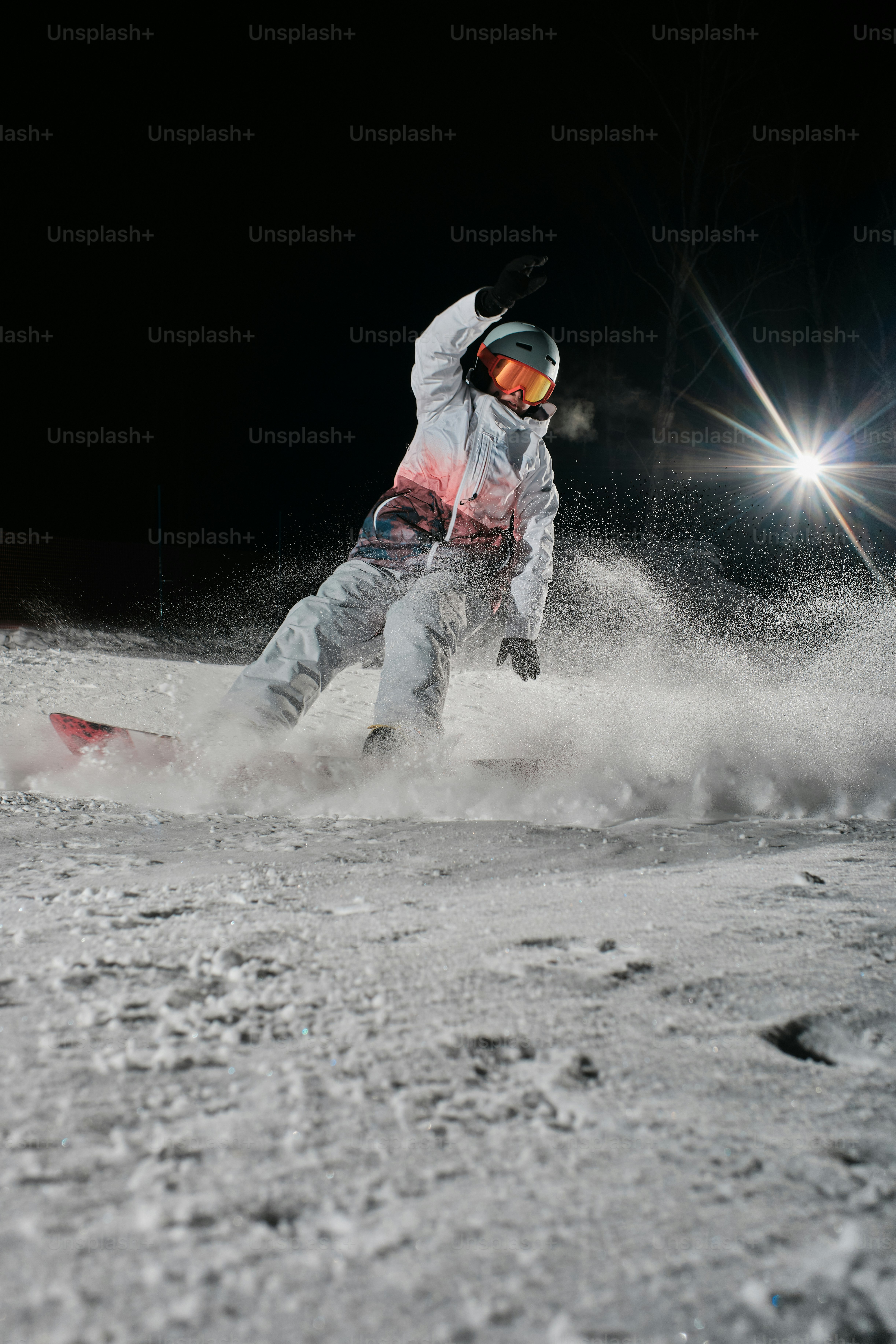 un uomo che cavalca uno snowboard lungo un pendio innevato