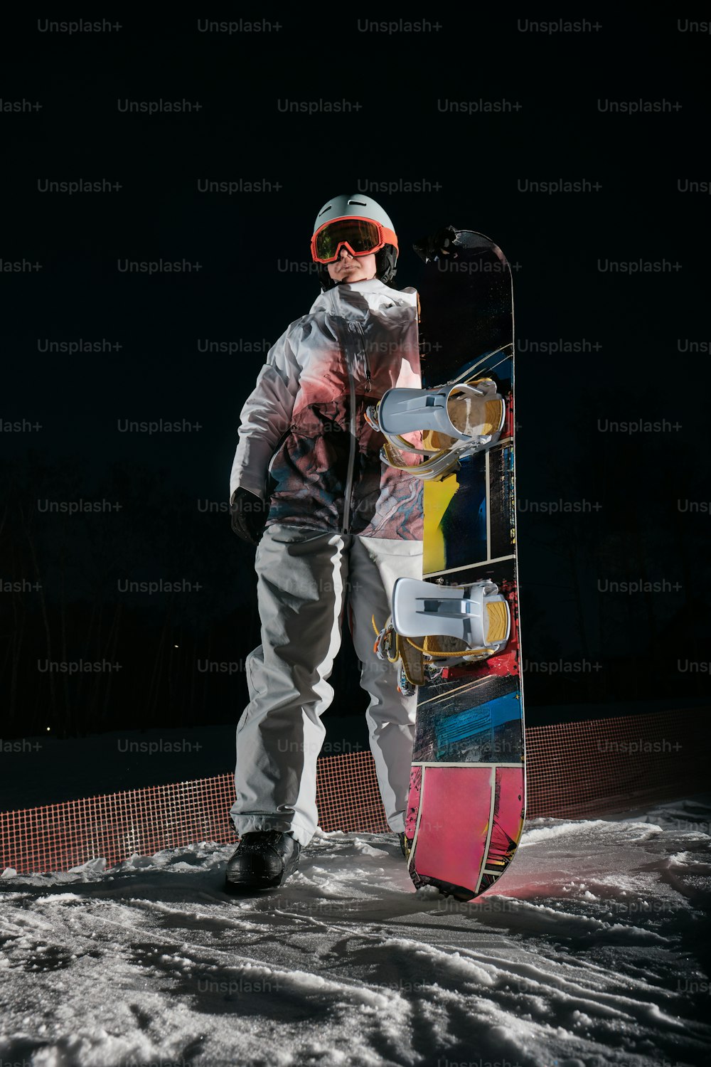 a man holding a snowboard on top of a snow covered slope