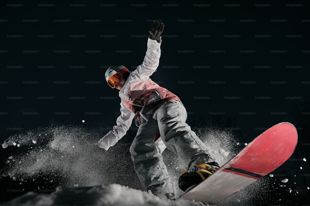 a man riding a snowboard down a snow covered slope