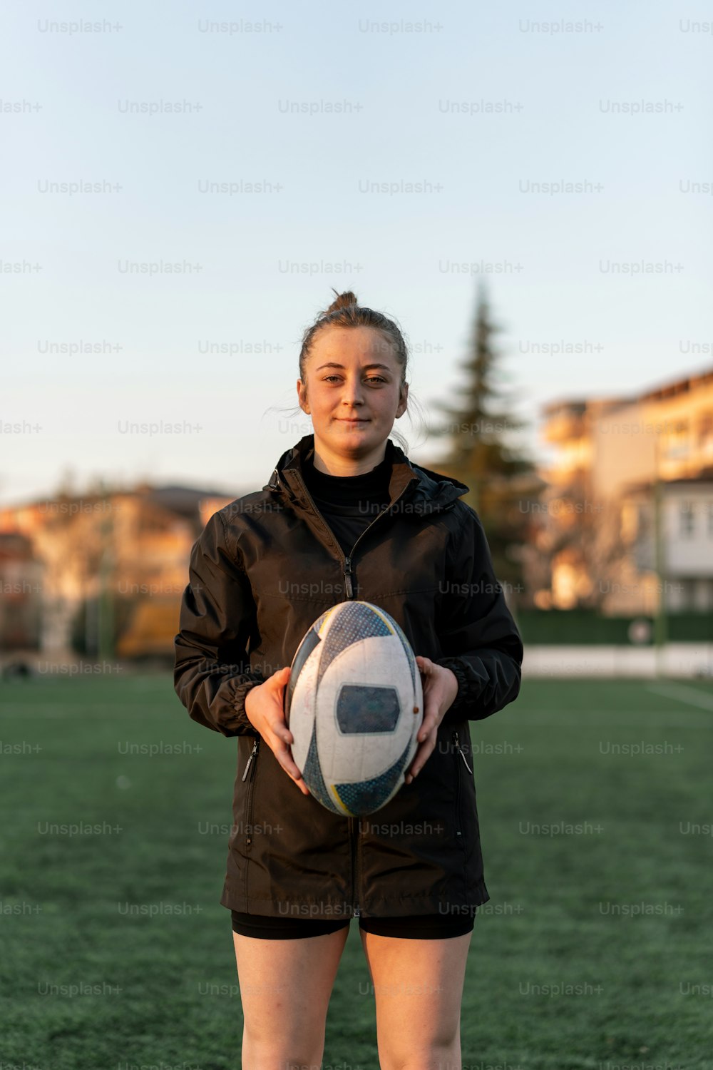 a woman holding a soccer ball on a field