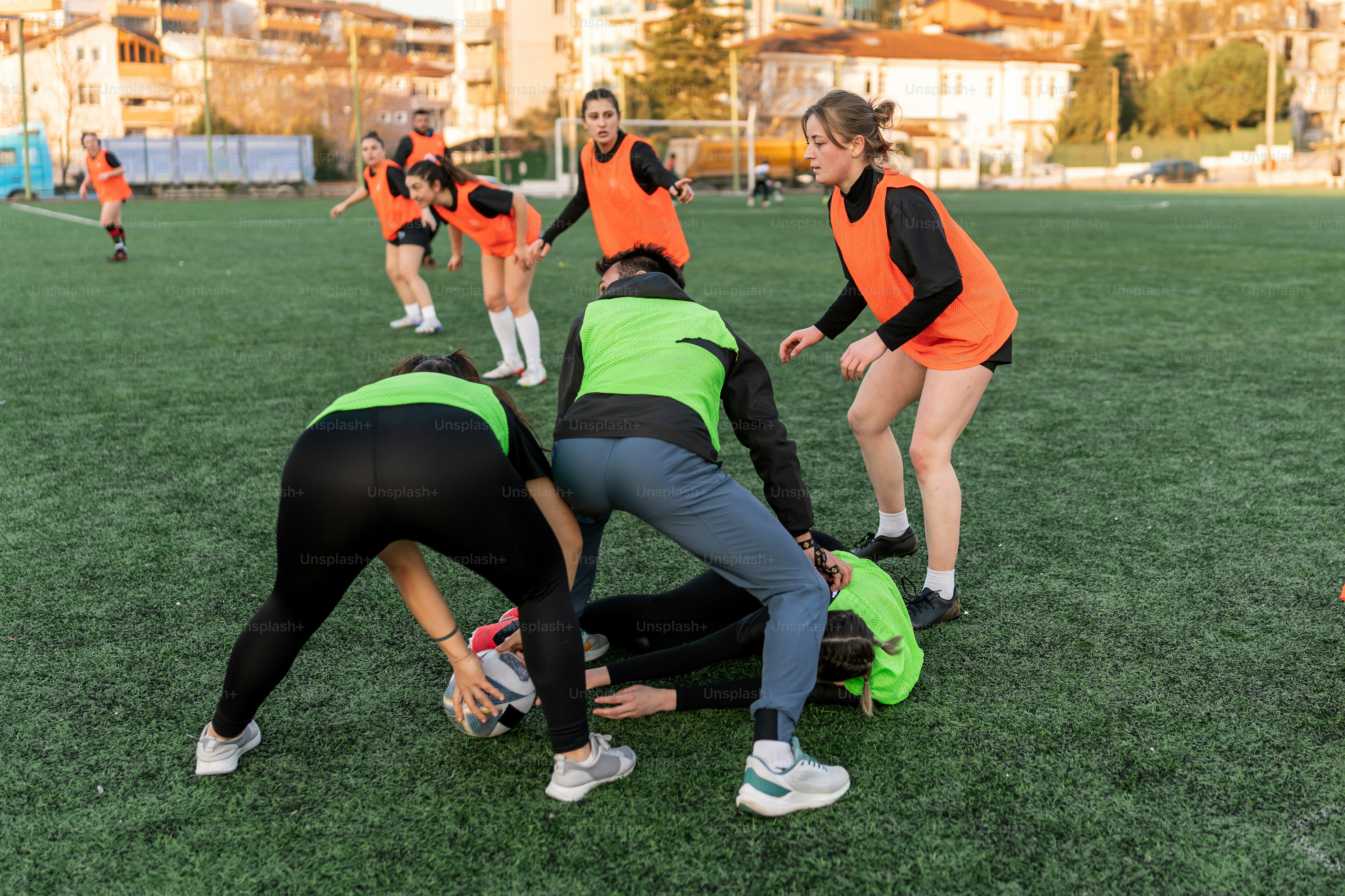 a group of women in orange shirts playing soccer