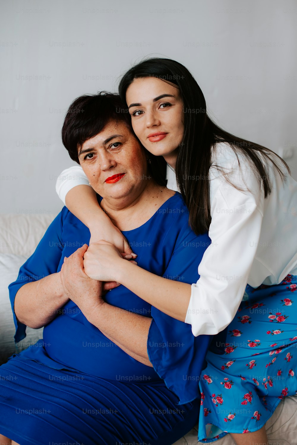 a woman hugging another woman on a bed