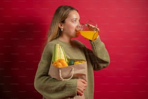 a woman drinking a glass of orange juice