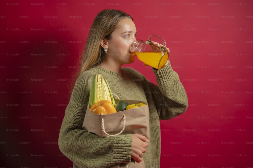 a woman drinking a glass of orange juice