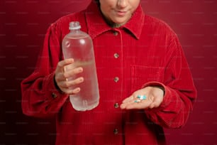 a woman in a red shirt holding a bottle of water