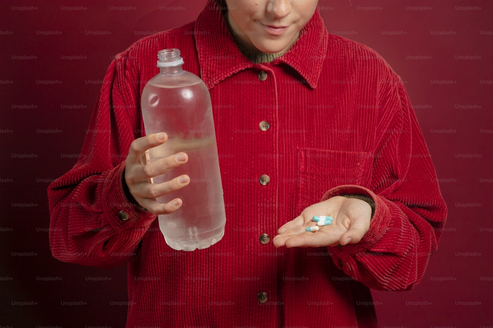 a woman in a red shirt holding a bottle of water