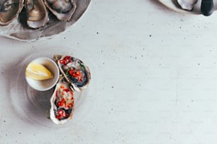 a plate of oysters with a lemon wedge on the side