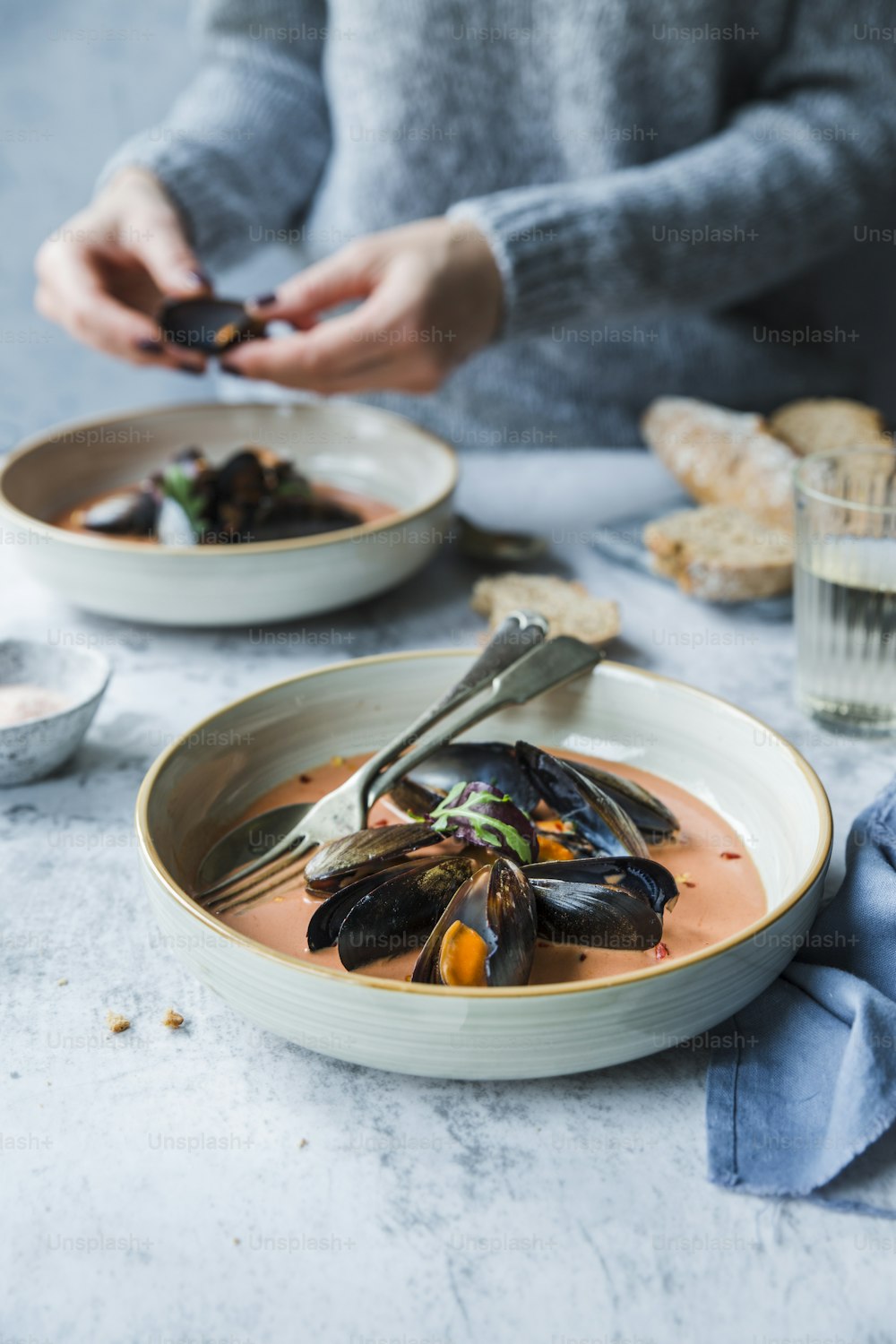 a bowl of mussel soup with a spoon in it