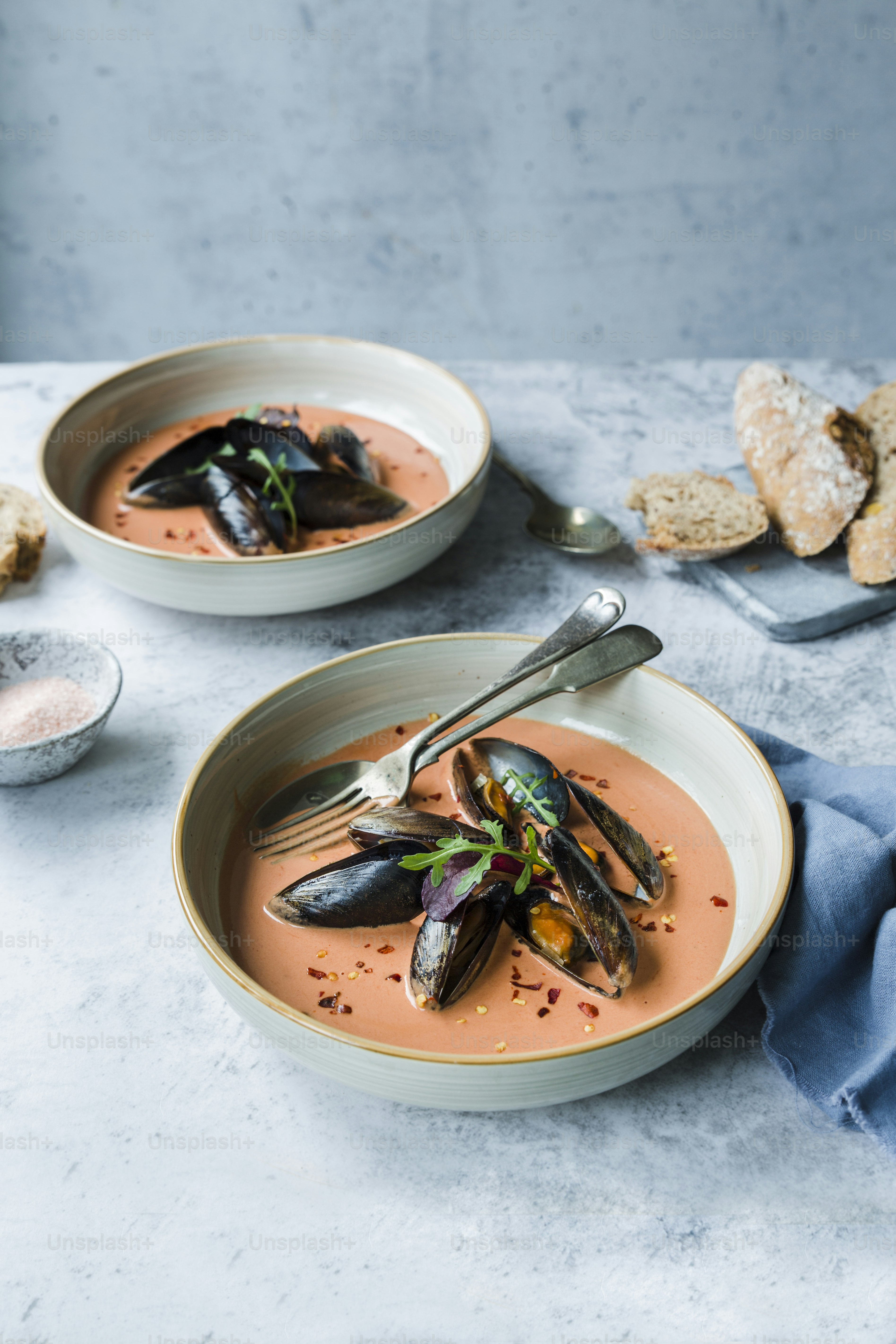 eine Schüssel Suppe mit Muscheln und einem Löffel