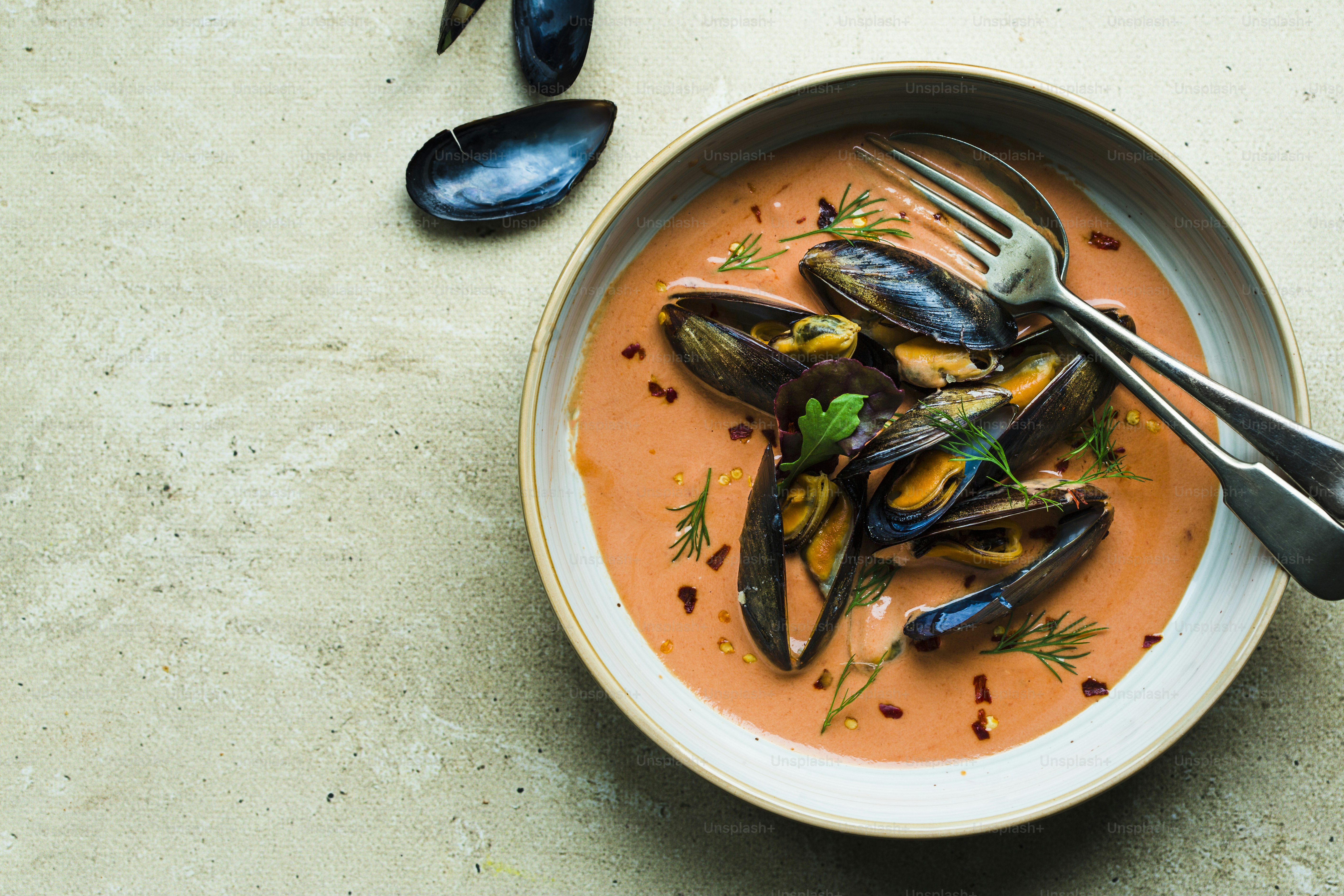 eine Schüssel Suppe mit Miesmuscheln und Beilagen