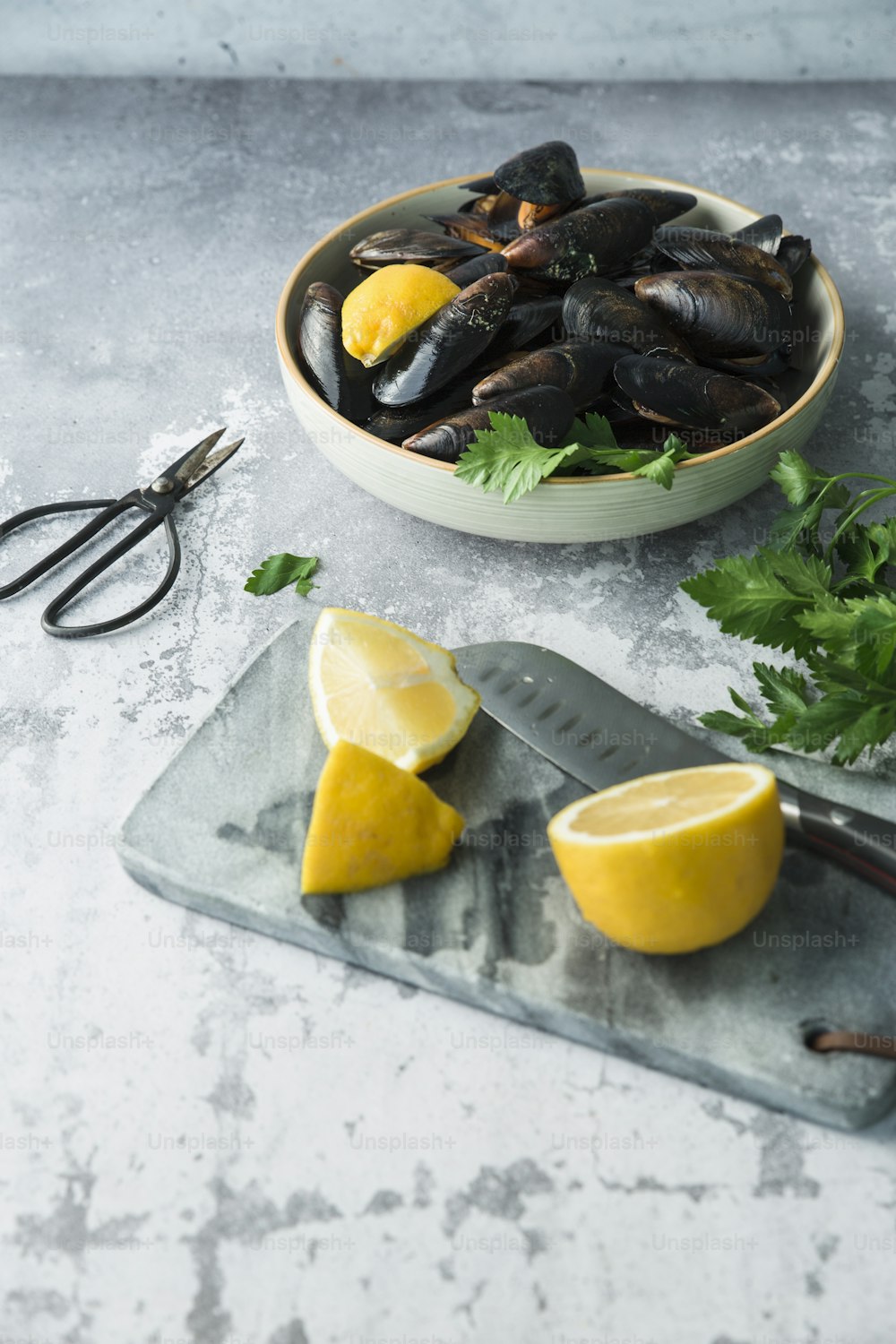 a plate of mussels with lemon and parsley