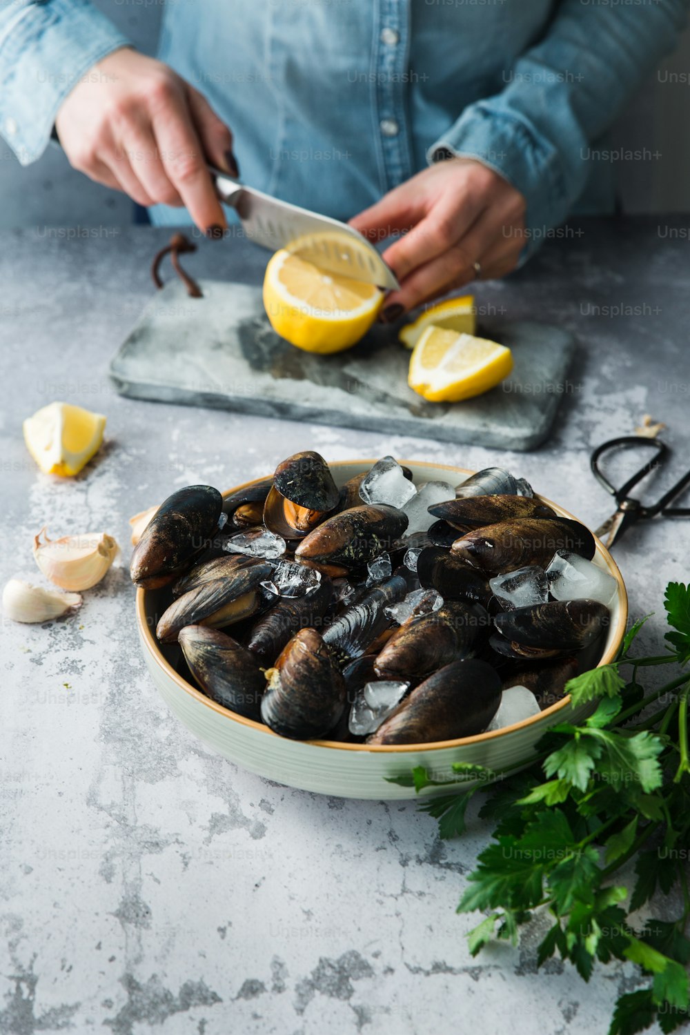 a bowl of mussels with lemon and parsley