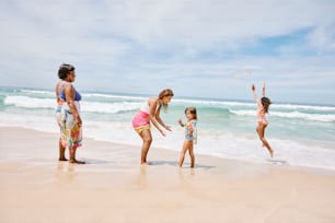 a group of people standing on top of a sandy beach