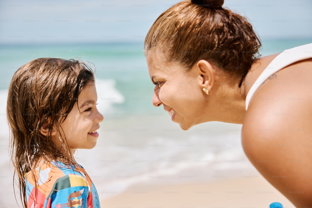 a woman and a little girl on the beach