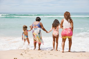 Un groupe de femmes se tenant la main sur la plage