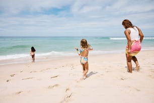 a group of people standing on top of a sandy beach