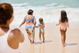 Un grupo de mujeres caminando por una playa junto al océano